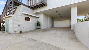 A two-story house with a covered driveway, a garage, and a small outdoor area with a potted plant. - Carpe Beachiem Home, Ocean Views & Dual Decks (Ponte Vedra Beach)