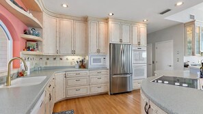 A kitchen with white cabinetry, stainless steel appliances, and a granite countertop.