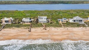 A beachfront property with multiple houses, a sandy beach, and a view of the ocean. - Carpe Beachiem Home, Ocean Views & Dual Decks (Ponte Vedra Beach)