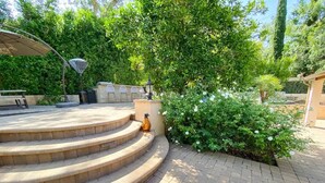 A set of outdoor steps leading to a patio area with a pergola, outdoor seating, and lush greenery. - 🌴Spacious & Private 5Bdr Private Retreat-Saltwater Pool/Spa, Outdoor Kitchen🌴 (Los Angeles)