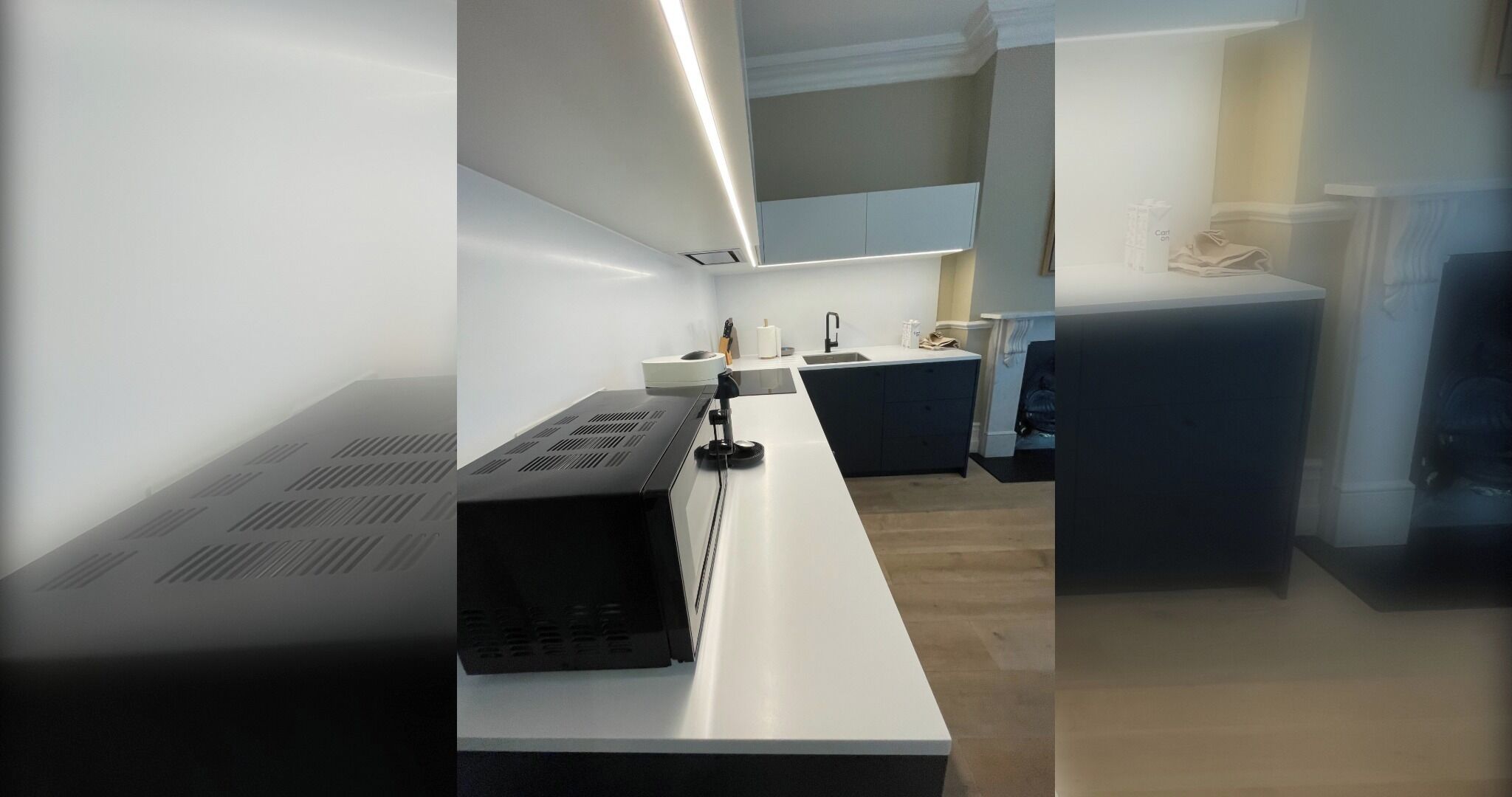 A modern kitchen with a long countertop, a sink, and cabinets.