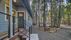 A house with a front porch, wooden steps, and a gravel driveway. - Secluded Butte Meadows Cabin w/ Deck & Grill! (Butte Meadows)