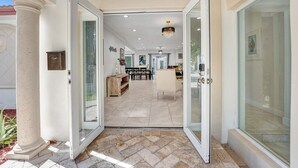 A spacious interior with a dining area, kitchen, and a large glass door leading outside.