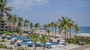 Un resort con piscina, playa y palmeras.