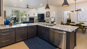 A modern kitchen with dark cabinetry, granite countertops, and stainless steel appliances. - Luxury Condo, Hot Tub, Balcony, Shuttle to Ski Slopes (Keystone)