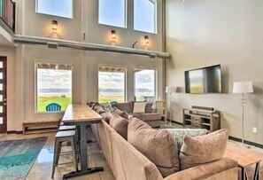 Relax in this open living area with a sofa facing a large window offering a view of the outdoors.