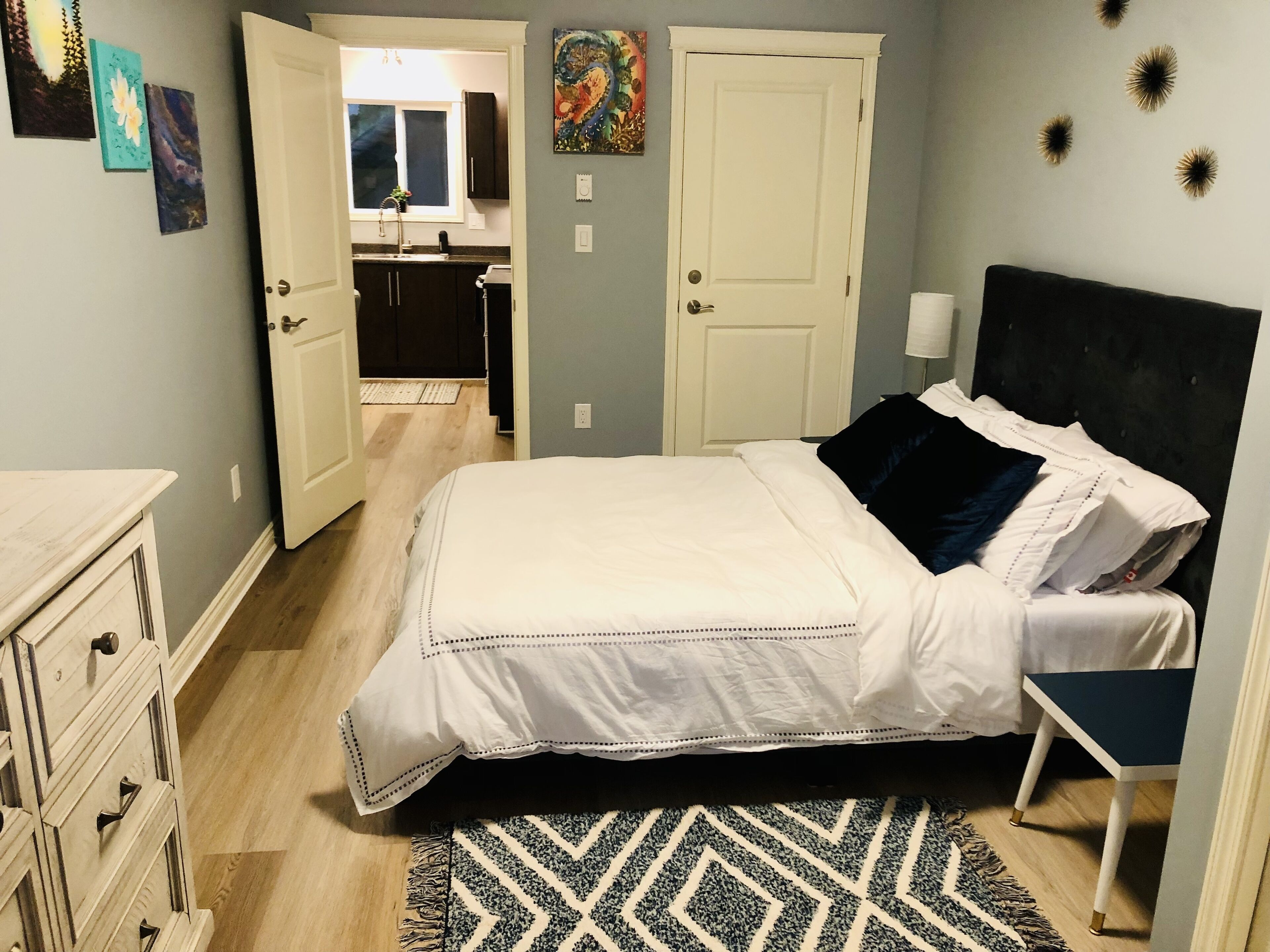 Een slaapkamer met een bed, een kaptafel en uitzicht op de badkamer.