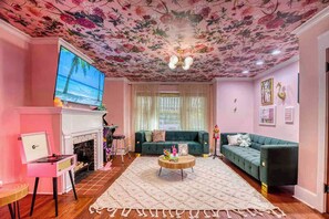 A living room with a fireplace, a television, a sofa, and a coffee table.