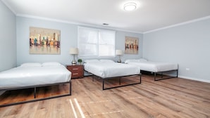 A bedroom with three single beds, a window with blinds, and two wall-mounted lamps. - Beautiful, Remodeled Penthouse Unit in Old Town! (Chicago)