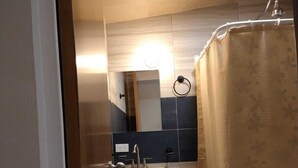 Een moderne badkamer met een wastafel, spiegel en douchegordijn.