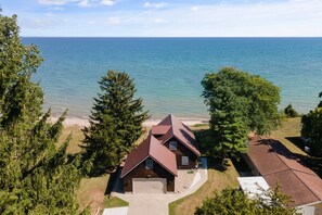 A house with a red roof, a garage, and a view of the ocean. - Golf n Shores - Hot tub (open all yr), kayaks&more (Sanilac Township)
