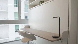 A modern office space with a desk, chair, and a lamp. - Lovely studio unit in Miami-Van Dennis (Miami)