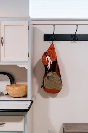A simple, functional space with a cabinet, wall-mounted rack, and wooden bowls.