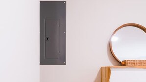 Une pièce avec une chaise jaune, une commode blanche et un tapis gris.