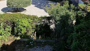 Ein Küstenwohngebiet mit Reihenhäusern, einem gepflegten Garten und freiem Blick auf das Meer.