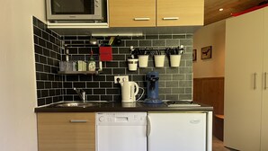 A compact kitchen with a microwave, coffee maker, and dishwasher. - Apartment at the foot of the slopes (Morzine)
