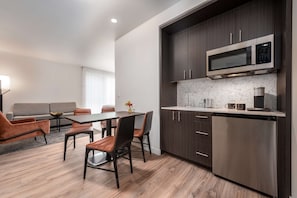 A modern kitchen with dark wood cabinets, a stainless steel microwave, and a dishwasher.