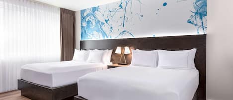 A hotel room with two beds, a large abstract painting on the wall, and a window with sheer curtains.
