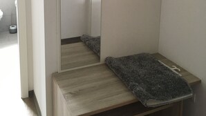 Et badeværelse med en trævægskab, et spejl og et håndklæde på bordet.