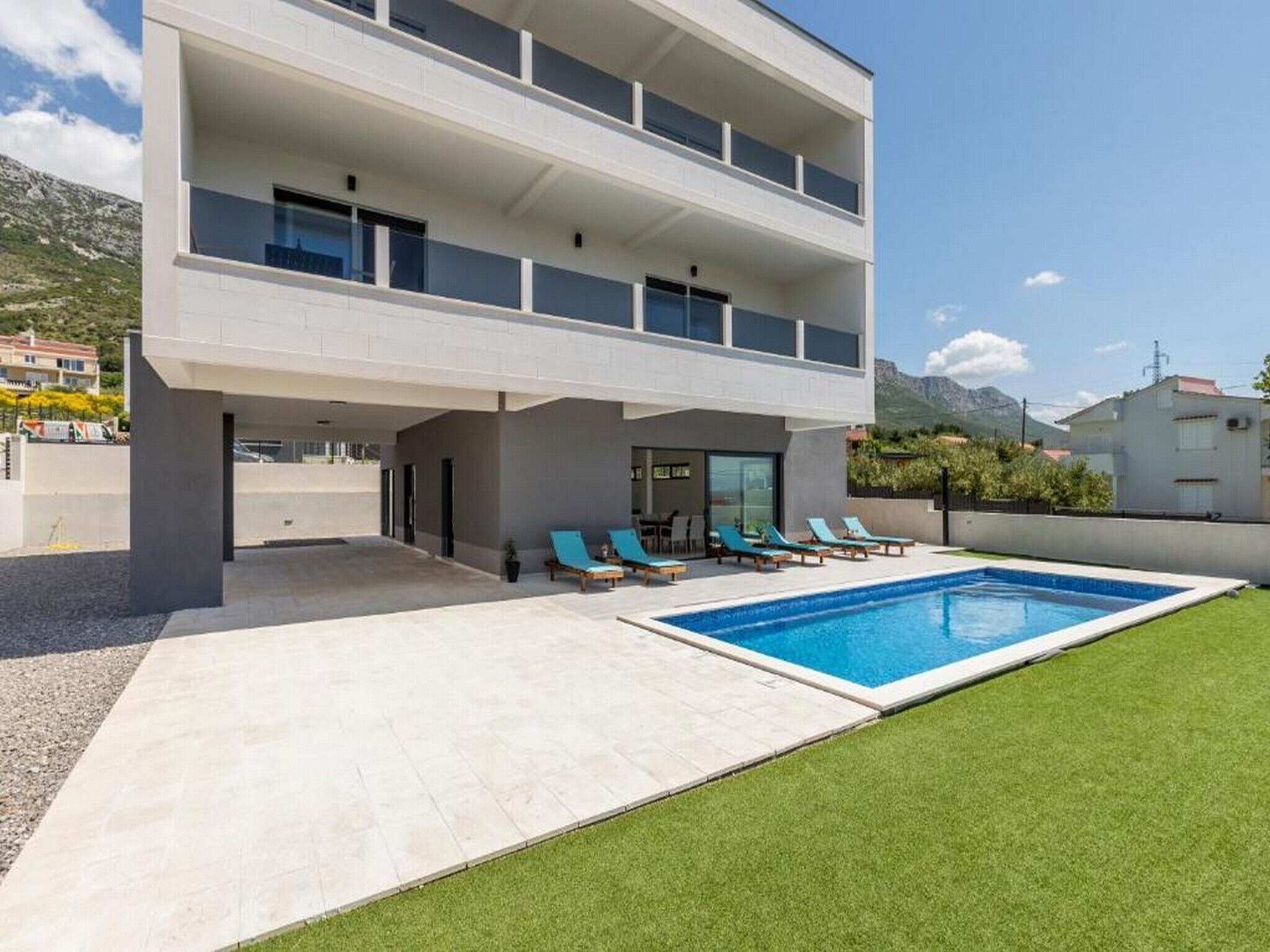 A modern two-story building with a swimming pool and outdoor seating.