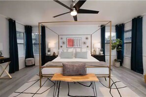 A modern bedroom with a four-poster bed, a ceiling fan, and a bedside table with a lamp. - Elegant Oasis•Near I-40, Rt66, Downtown•Families (Amarillo)