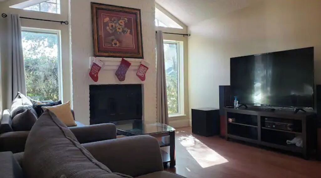Una sala de estar con chimenea, un televisor de pantalla plana grande y un sofá.