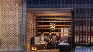 A modern outdoor seating area with a pool, wooden slatted walls, and a brick backdrop. - Luxury 2 Bedroom Arlington Apartment (Arlington)