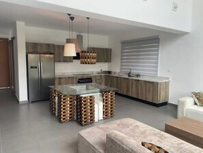 Enjoy cooking in this well-equipped kitchen with a central island, stainless steel appliances, and ample cabinetry.