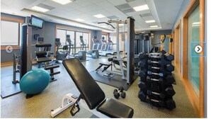 A gym with various exercise equipment, including treadmills, weight machines, and free weights. - Luxury 2 Bedroom Apartment in Heart of Reston Town Center (Reston)