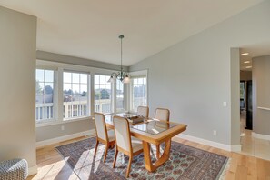 A dining area with a wooden table, four chairs, and a patterned rug. - Stunning Lakeside House w/ Deck + Water Views (Lakeside)