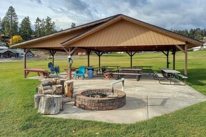 A covered picnic area with benches, picnic tables, and a fire pit. - Stunning Lakeside House w/ Deck + Water Views (Lakeside)
