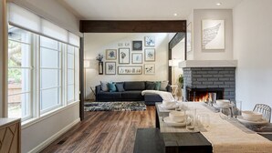 Una sala de estar moderna con chimenea, un sofá y un comedor listo para una comida.