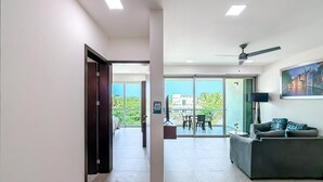 Ein modernes Hotelzimmer mit Balkon, Essbereich und Wohnbereich.