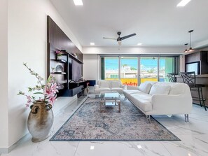 Ein modernes Wohnzimmer mit Sofa, Couchtisch und einer großen Vase mit Blumen.