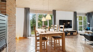 A spacious living area with a wooden dining table, chairs, a TV, and a sofa. - Lovely home in Fjerritslev with WiFi (Fjerritslev)