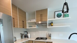 A modern kitchen with wooden cabinets, stainless steel appliances, and white countertops. - Wine, Lake, Repeat I City Edge Retreat Naramata Wine Gateway (Penticton)