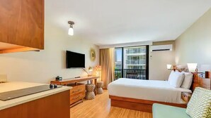 A hotel room with a bed, a desk, a chair, a TV, and a balcony with a view. - Waikiki Studio with Balcony & incredible pool Sleeps 3 (Honolulu)