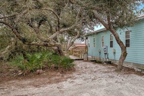 Standalone building with a flat roof and front porch, surrounded by trees and vegetation.