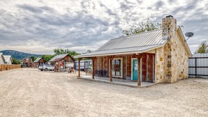 A rustic building with a stone facade, a covered porch, and a satellite dish.