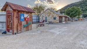 A rustic building with a wooden sign reading "Garner State Park" and "River Life". - Tiny home by the Frio River - River Rock Cabin #4 (Concan)
