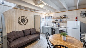 Una cocina acogedora con techo de madera, una mesa redonda de madera y un sofá.