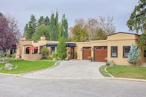 Une maison à deux étages avec une allée menant à l’entrée, un garage et une pelouse aménagée.