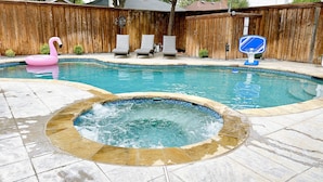 A backyard with a swimming pool, a hot tub, and a basketball hoop. - Private Family Heated Pool and Spa, 2 King Beds, Cornhole, Grill, Foosball, Game (Richardson)