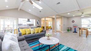 A spacious living area with a gray sofa, colorful striped rug, and a round coffee table. - Private Family Heated Pool and Spa, 2 King Beds, Cornhole, Grill, Foosball, Game (Richardson)