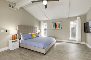A bedroom with a bed, nightstands, a ceiling fan, a window, and a painting on the wall. - Private Family Heated Pool and Spa, 2 King Beds, Grill, Foosball, Game, Cornhole (Richardson)