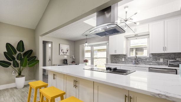 A modern kitchen with white cabinets, a large island with stools, a built-in stove, and a skylight. - Private Family Heated Pool and Spa, 2 King Beds, Cornhole, Grill, Foosball, Game (Richardson)