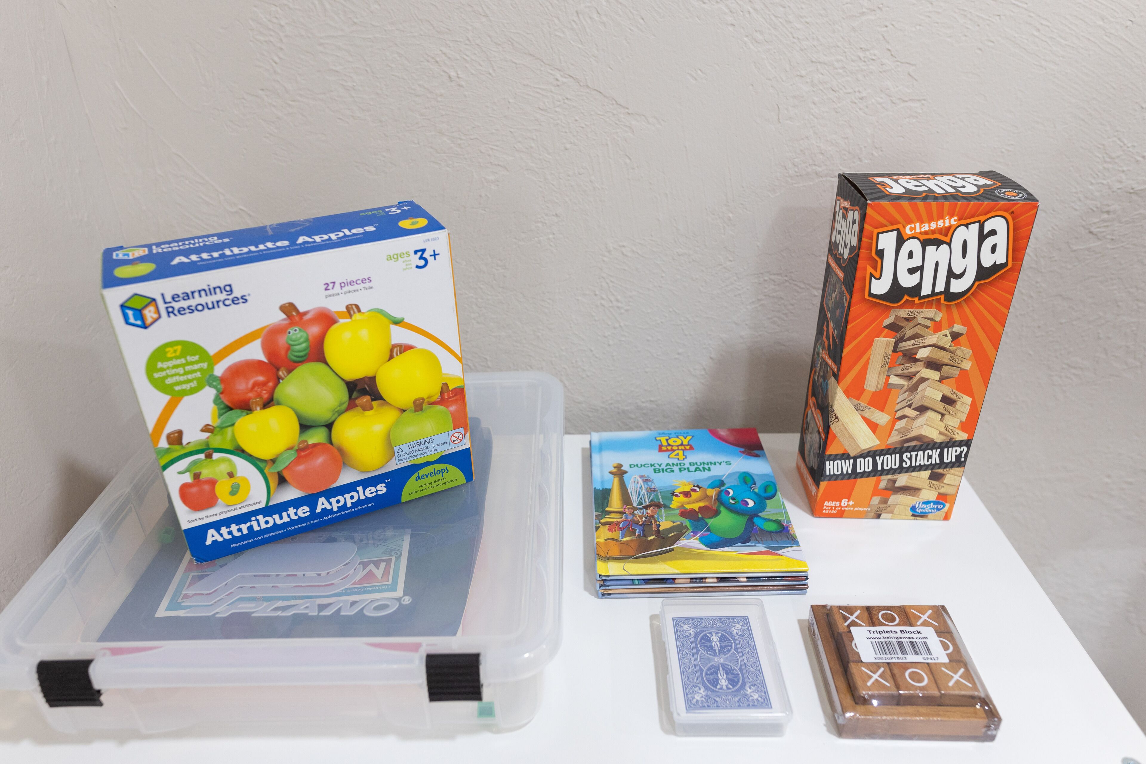 Eine Plastik-Aufbewahrungsbox mit einem Spielzeug und einem Buch darauf.
