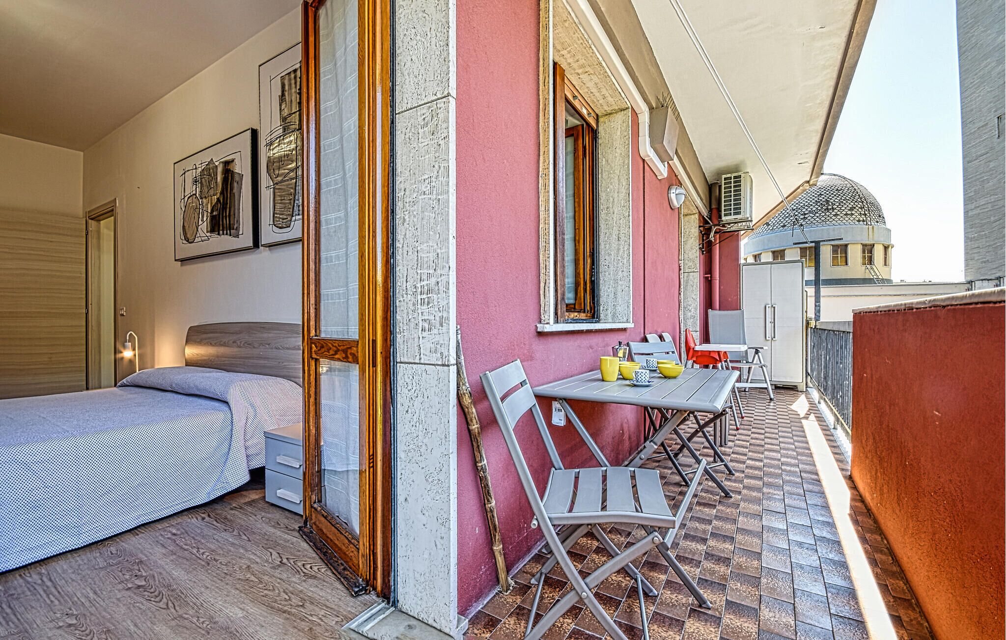 Ein Zimmer mit einem Bett, einem kleinen Tisch mit Stühlen, einem Fenster und einer Tür.