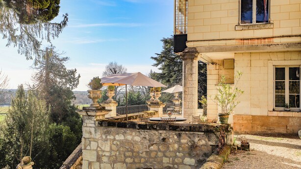 A stone balustrade with a view of the countryside, a covered outdoor seating area, and a building with a window. - Manoir de la Salle du Roc - romantic suite 30 M2 Joséphine, Near Chenonceau  (Montrichard Val de Cher)