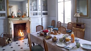 A dining room with a fireplace, wooden chairs, a table set for breakfast, and a large mirror on the wall. - Manoir de la Salle du Roc - romantic suite 30 M2 Joséphine, Near Chenonceau  (Montrichard Val de Cher)